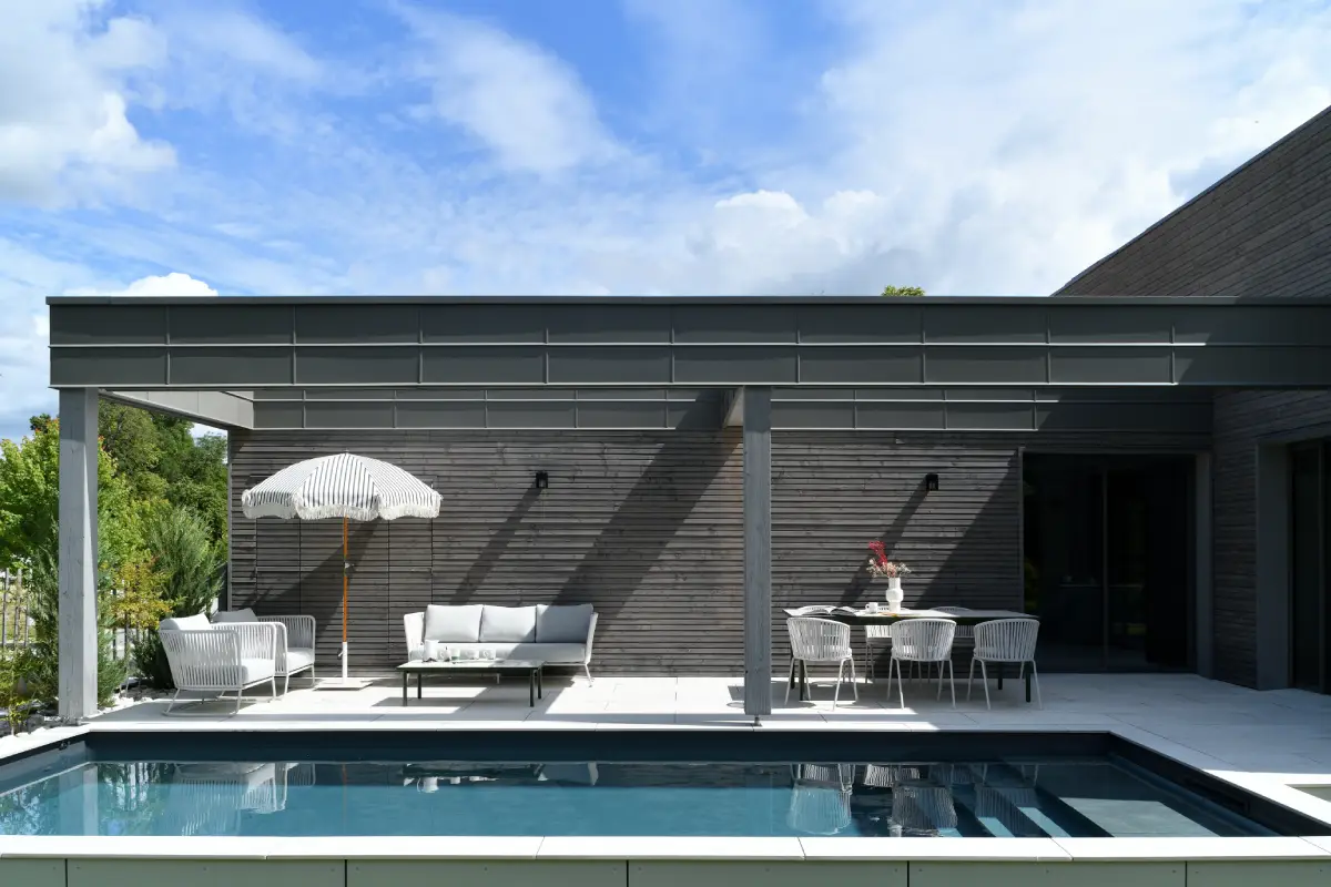 Villa G, à Aix-les-bains, extérieur présentant la piscine creusée de la villa, avec son aménagement extérieur une table à manger et des sofas
