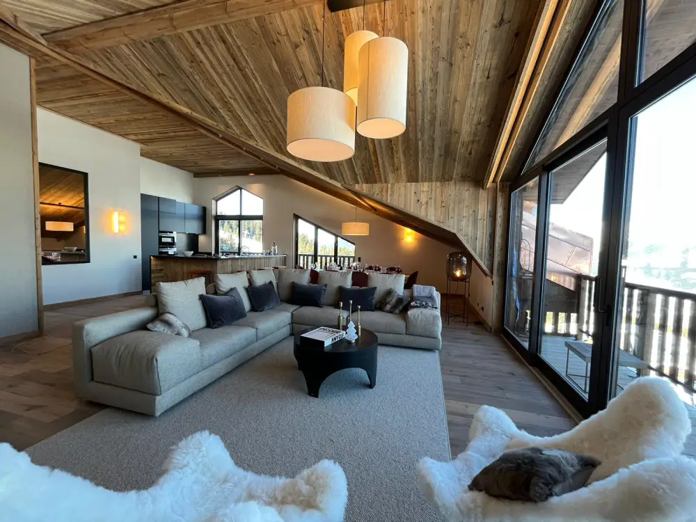 Appartement D, Courchevel, intérieur salon ambiance chalet de montagne avec plafond en bois et mobilier en matières brut et fourrure, des luminaires chaleureux