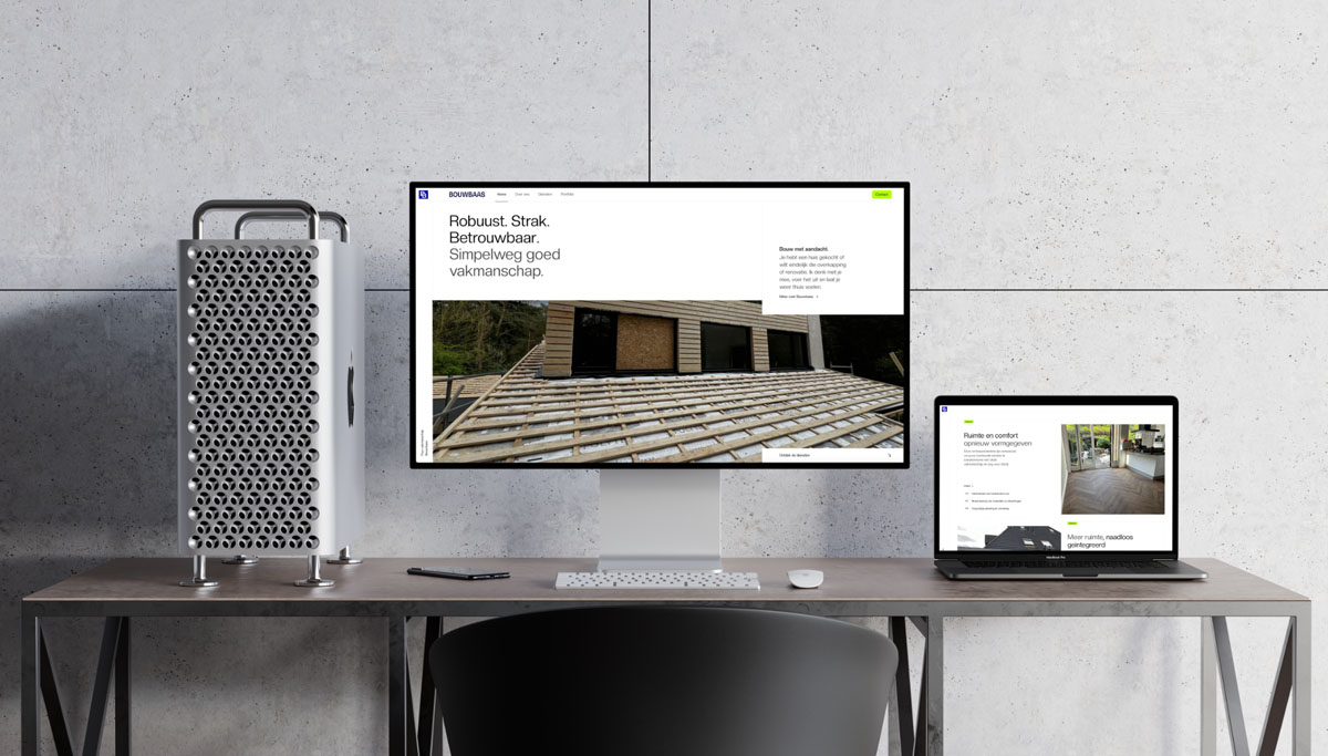 A modern desk setup featuring a Mac Pro, a desktop monitor, and a laptop displaying the responsive Bouwbaas website.