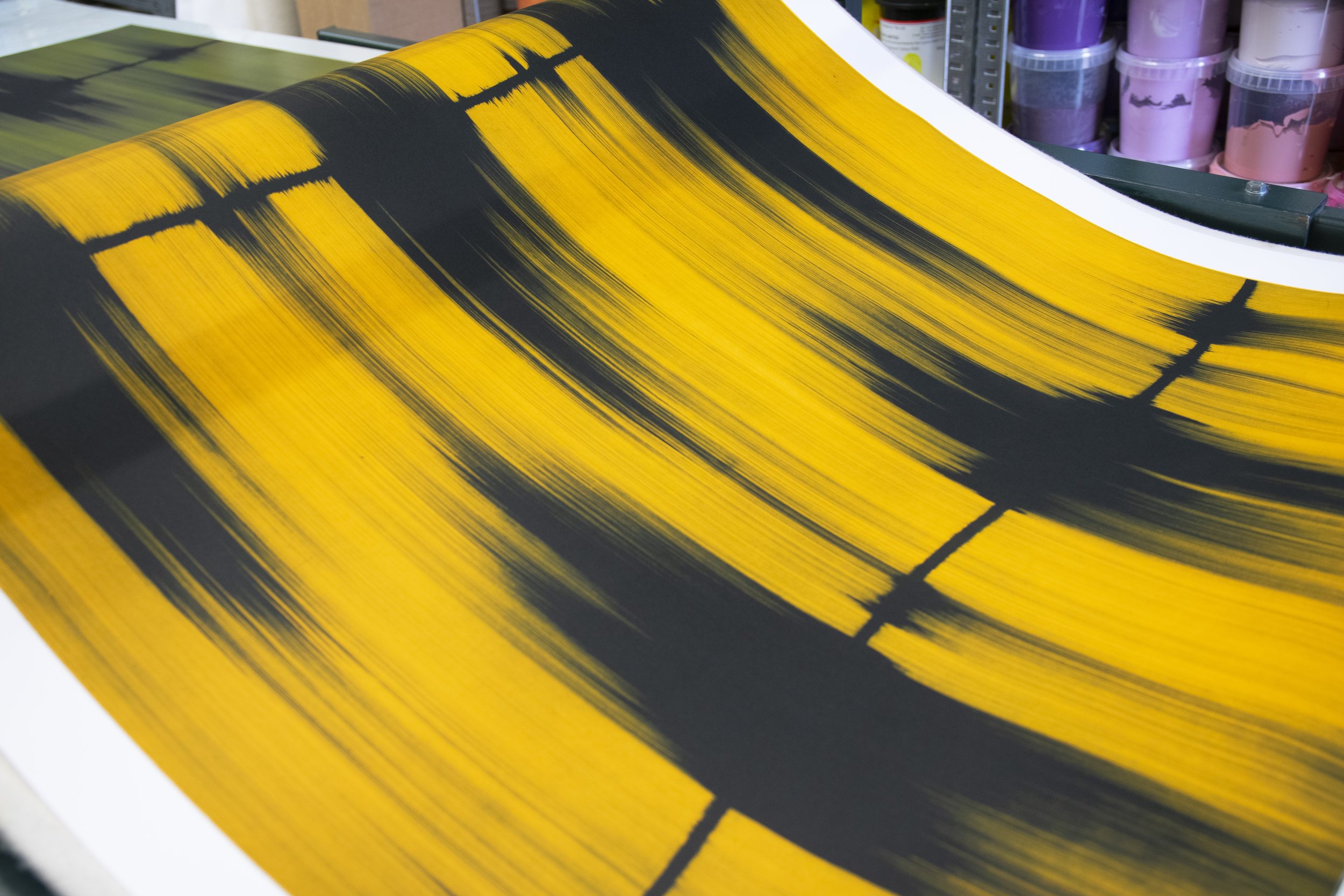 Mark Francis's yellow 'Echo' etching on the press mid-printing at the Atelier JI studio, a green edition of the set behind.