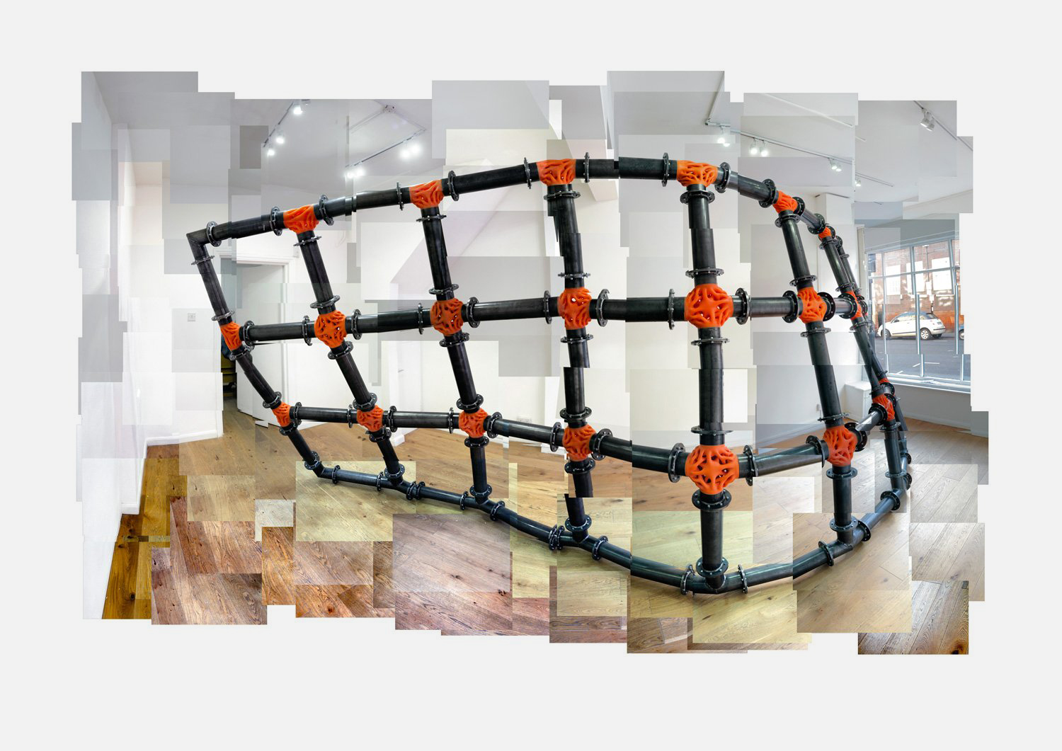 Luke Hart, Wall: a domed cage of black pipes joined by orange organic nodes, in a gallery shown as a tiled photomontage.  The framing here does double duty for Hart's practice — the black industrial pipework against the organic orange lattice joints is exa