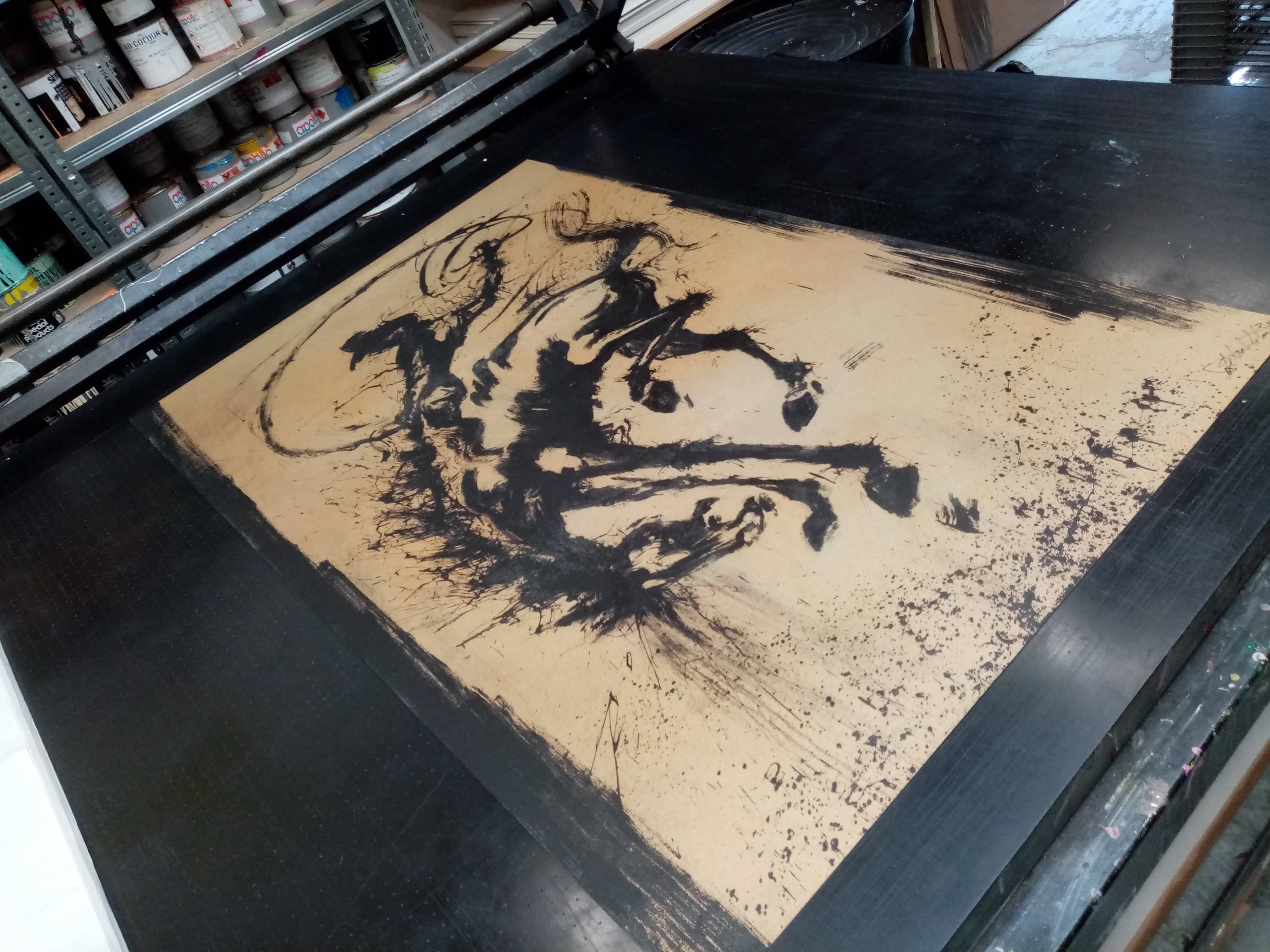 Horse and Rider in production: the silkscreen on the press bed beside shelves of ink tins.