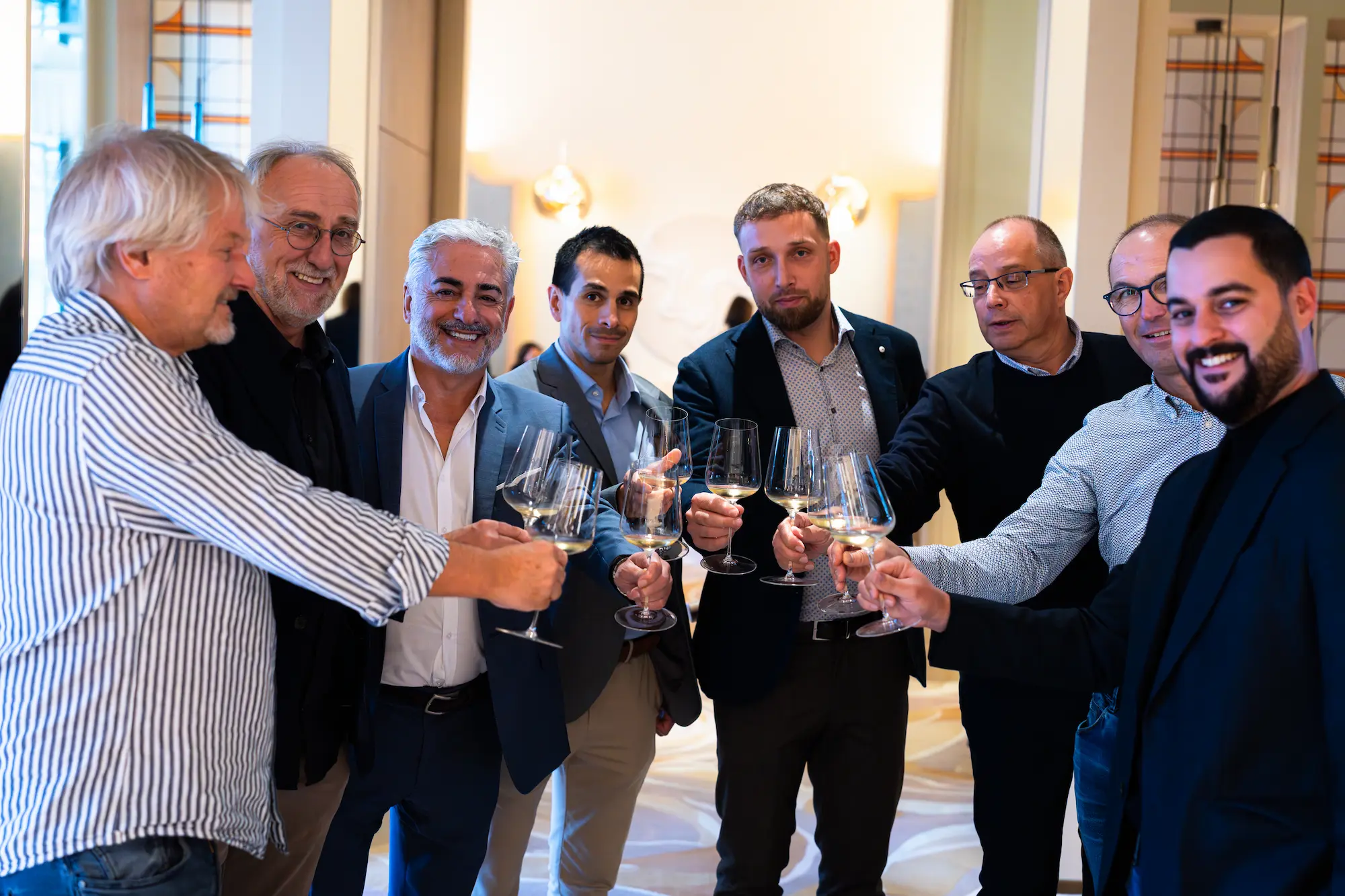 Photo de groupe d'une équipe trinquant lors d'un événement d'entreprise en Suisse romande, photographiée par Pixera