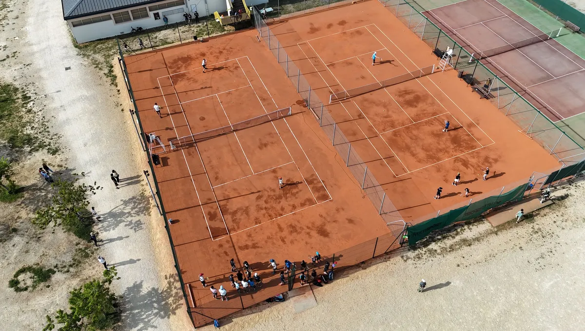 Court de tennis en terre battue artificielle sur moquette aiguilletée