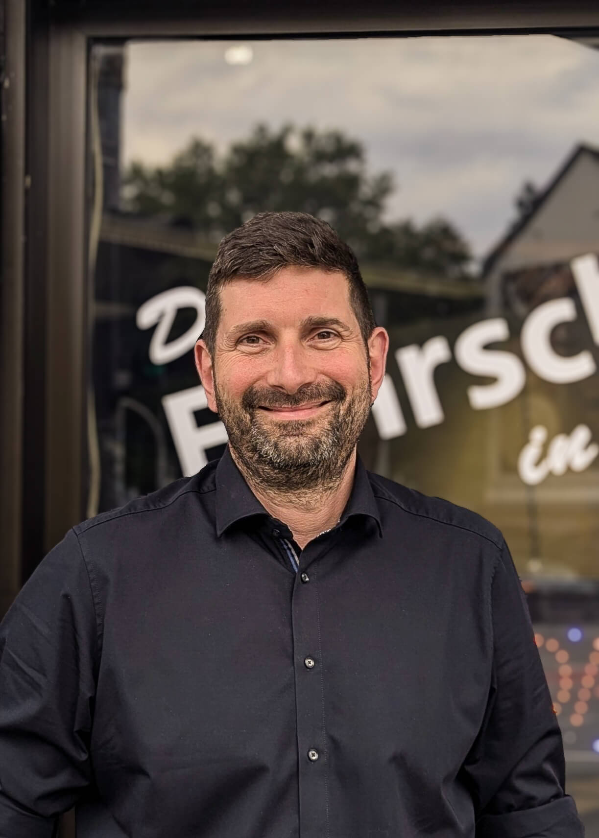 Porträt eines Fahrlehrers vor seiner Fahrschule