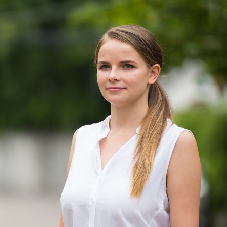 Porträt einer Fahrlehrerin draußen vor unscharfem Hintergrund