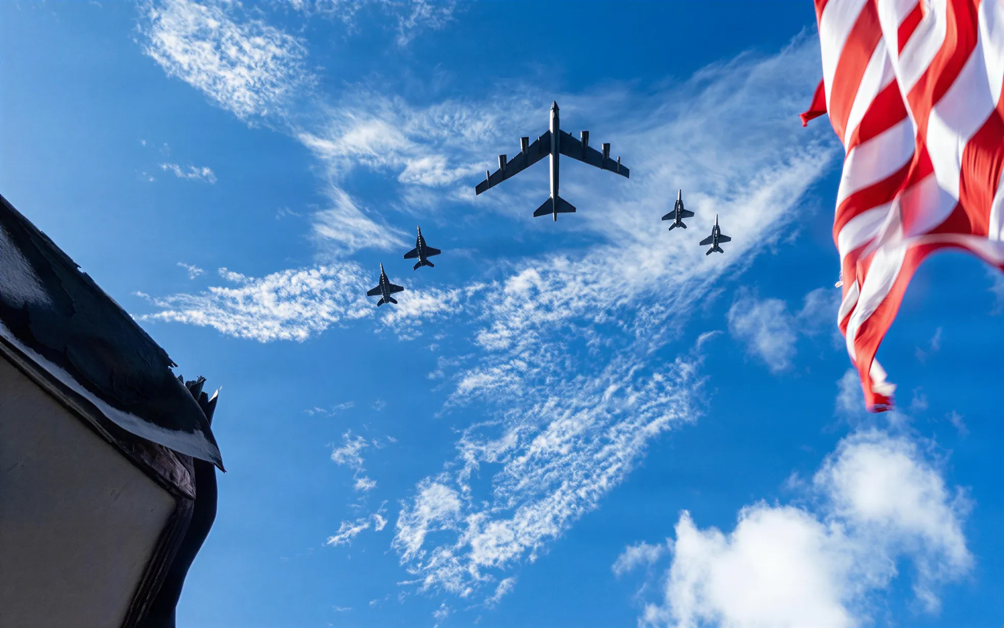 Military aircraft in formation above a US flag