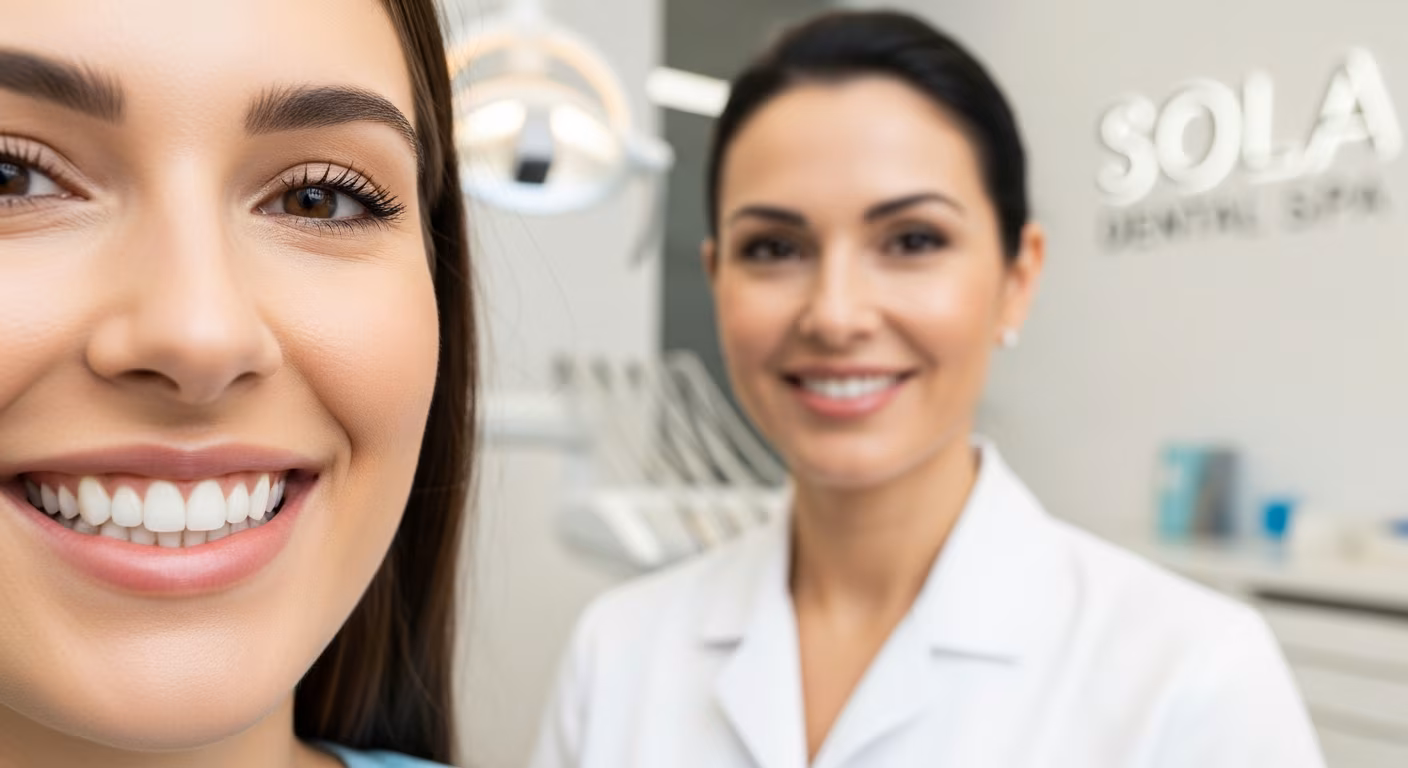 Close-up of a patient with a dazzling, confident smile after getting porcelain veneers, a professional female cosmetic dentist from Sola Dental Spa is smiling in the background, clinic setting, bright and inviting, soft lighting.