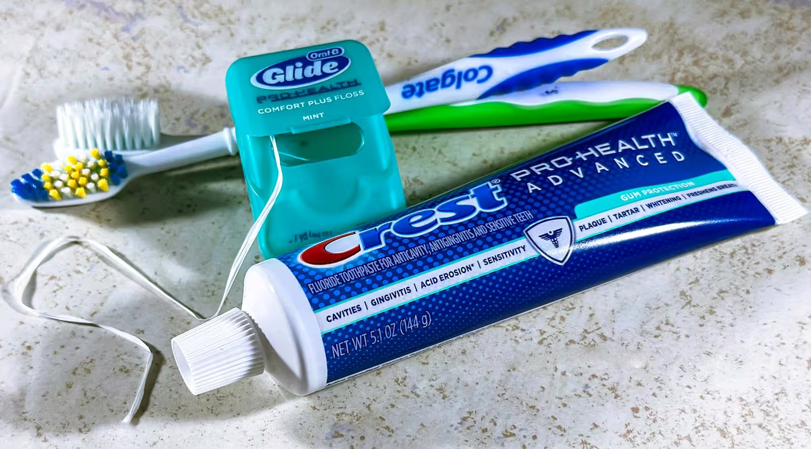 Drugstore teeth whitening strips and trays next to a professional whitening kit