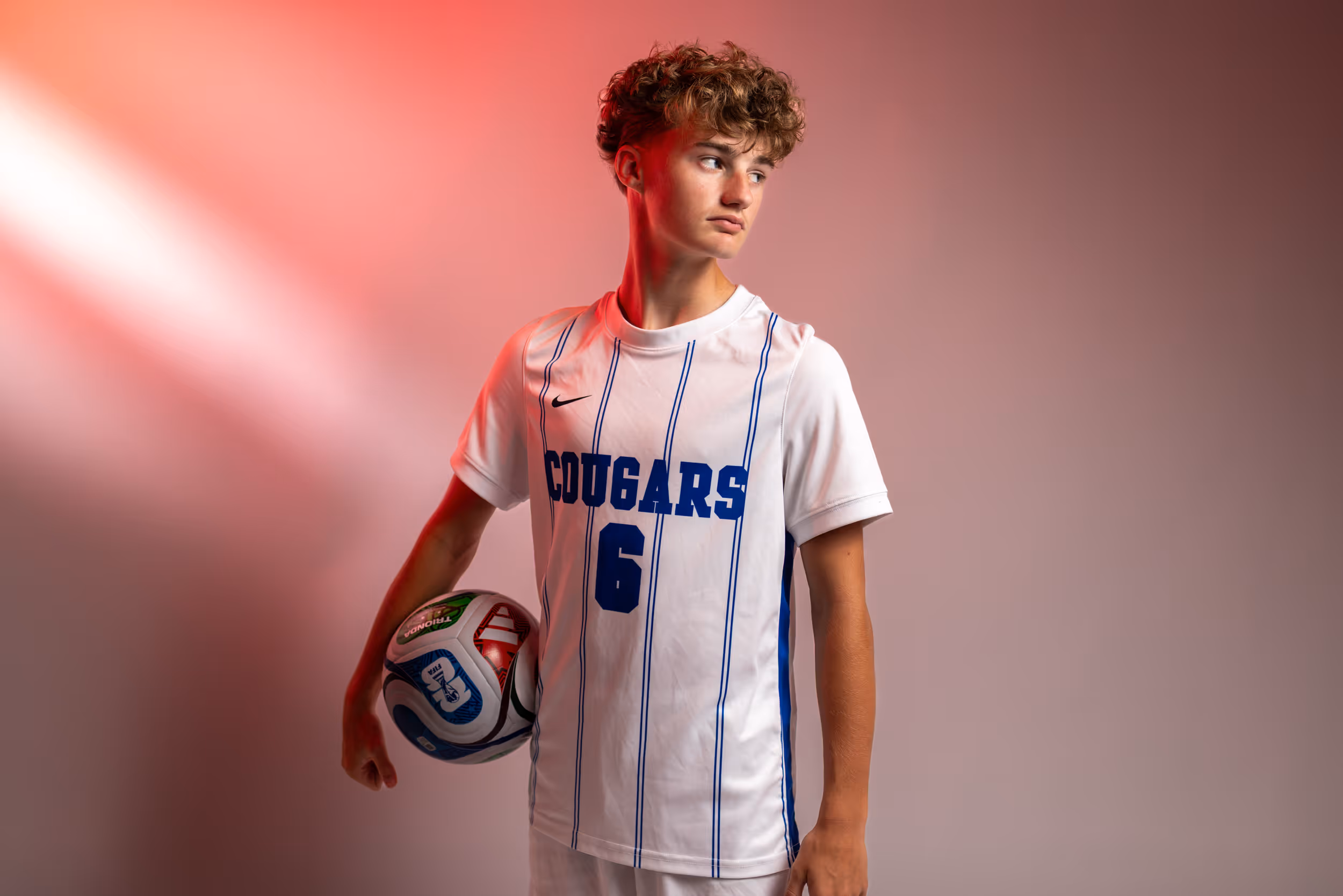 Weston Ochs holding a soccer ball under his arm.