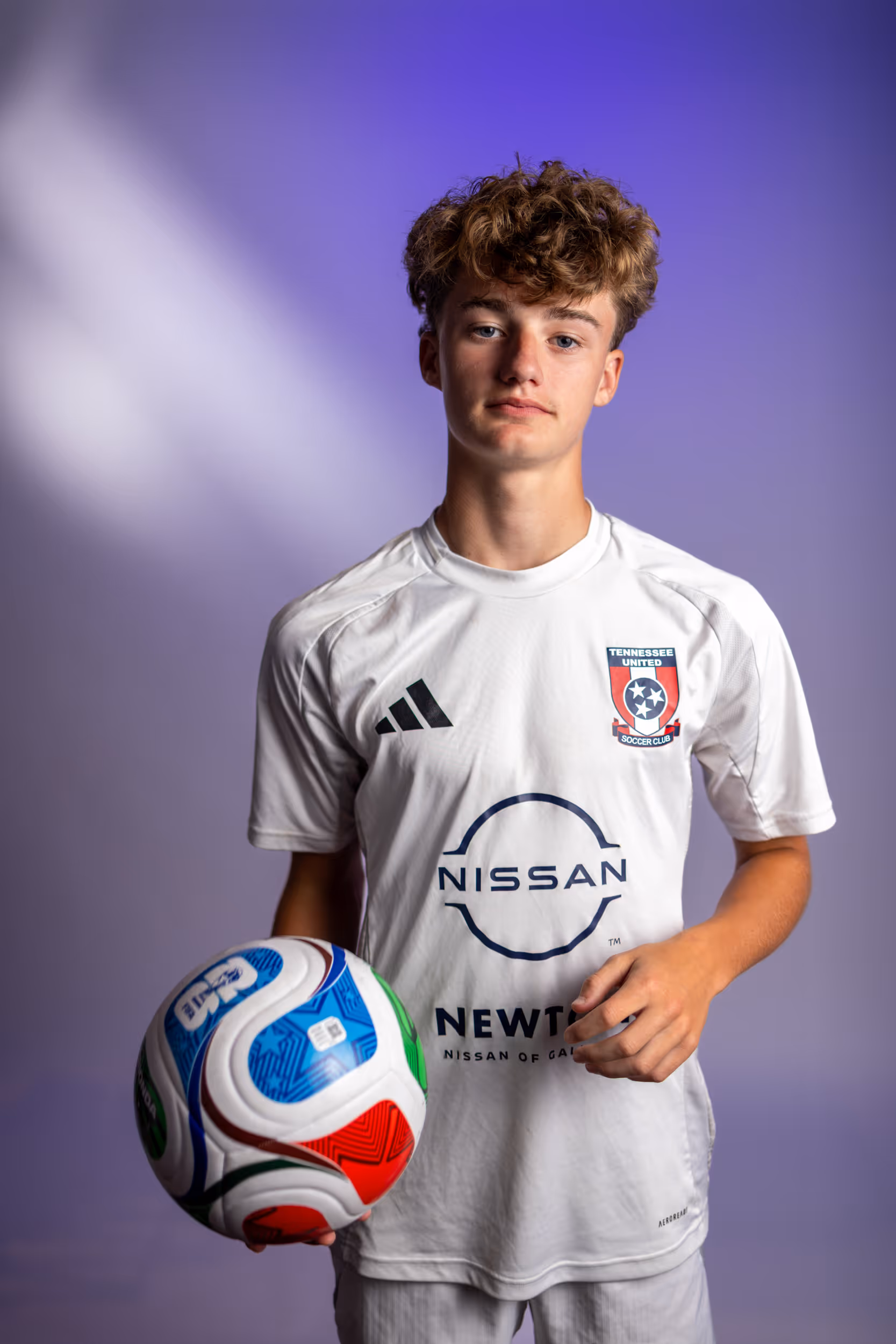 Weston Ochs in white Tennessee United jersey holding a colorful soccer ball.