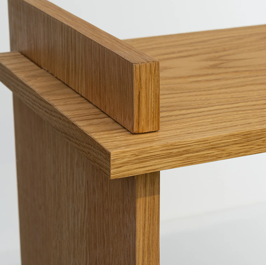 Close-up of a simple wooden table corner showing smooth grain and clean joinery.