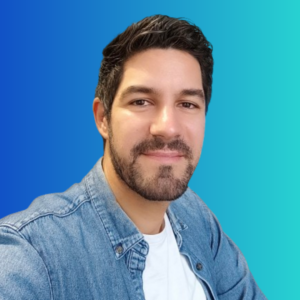 Jeune homme souriant portant une chemise en jean et un t-shirt blanc avec un fond dégradé bleu.
