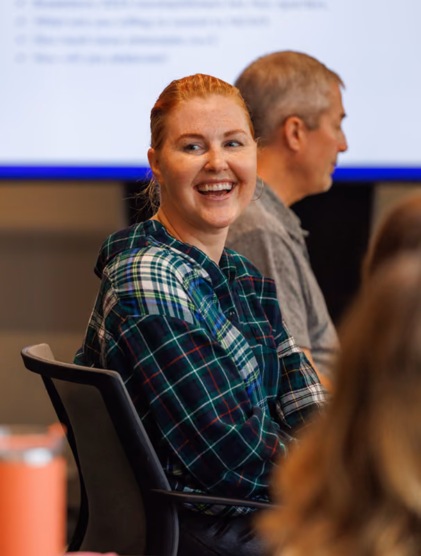 A woman at a conference table smiles