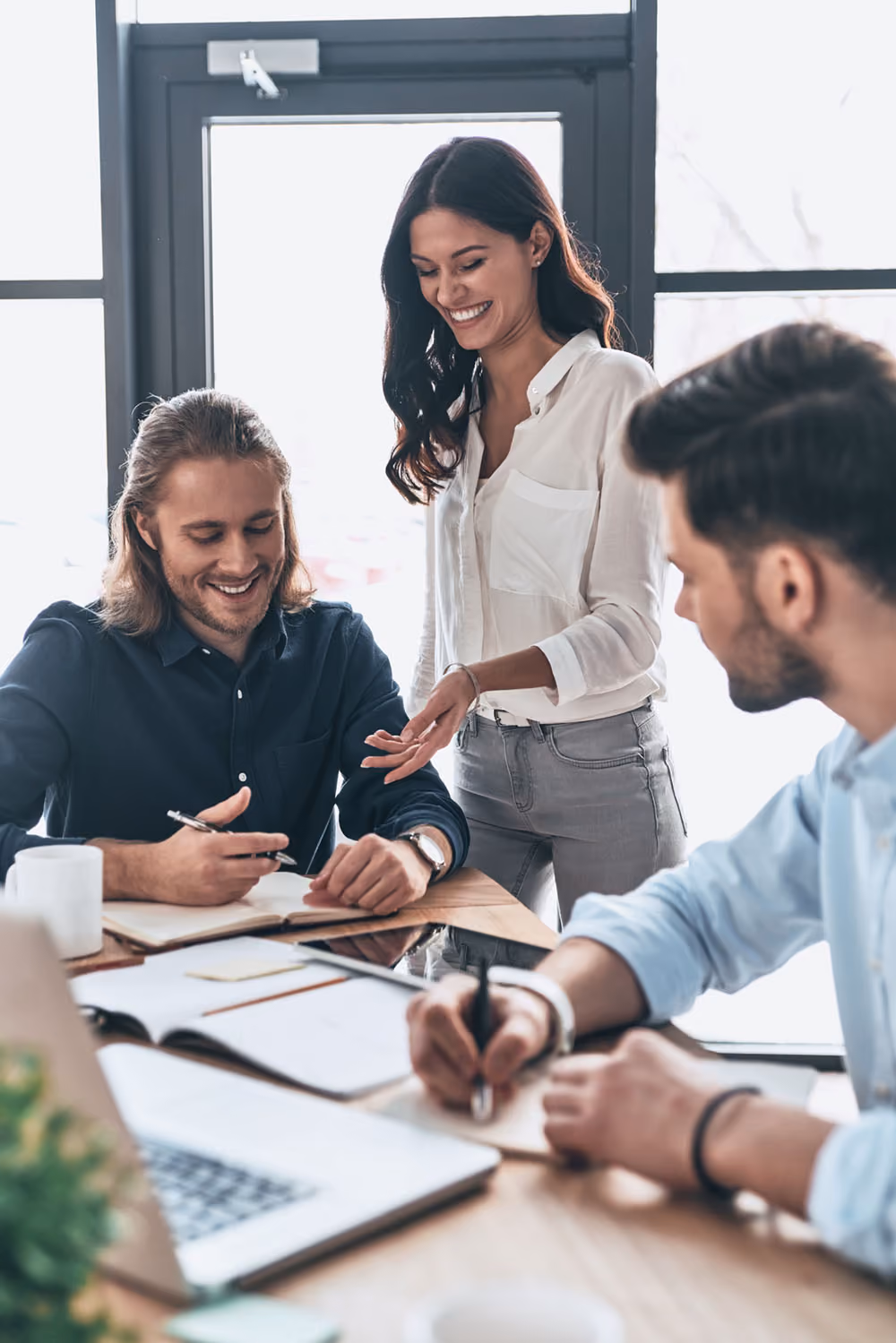 Two men and a woman co-working in a meeting space