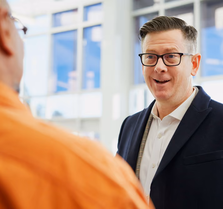 A man in a suit speaking to somebody out of frame