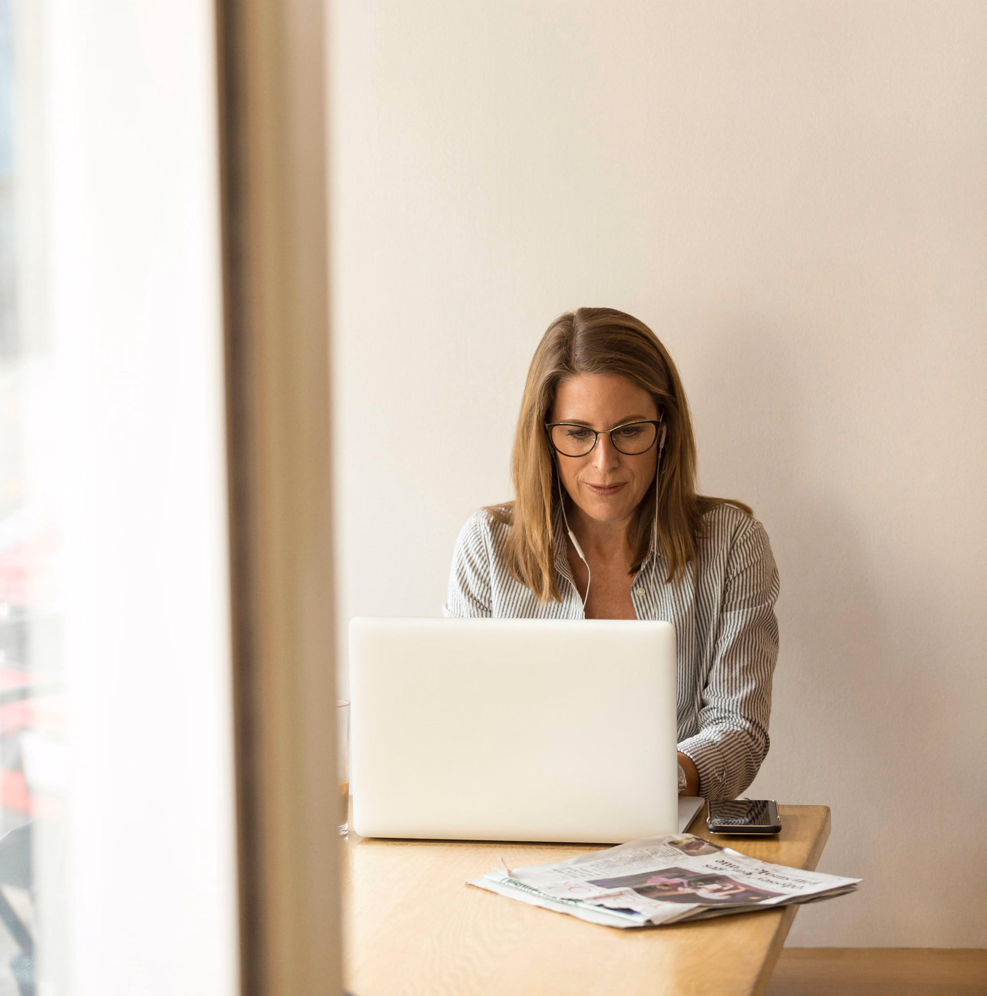A woman in business attire looking at a computer.