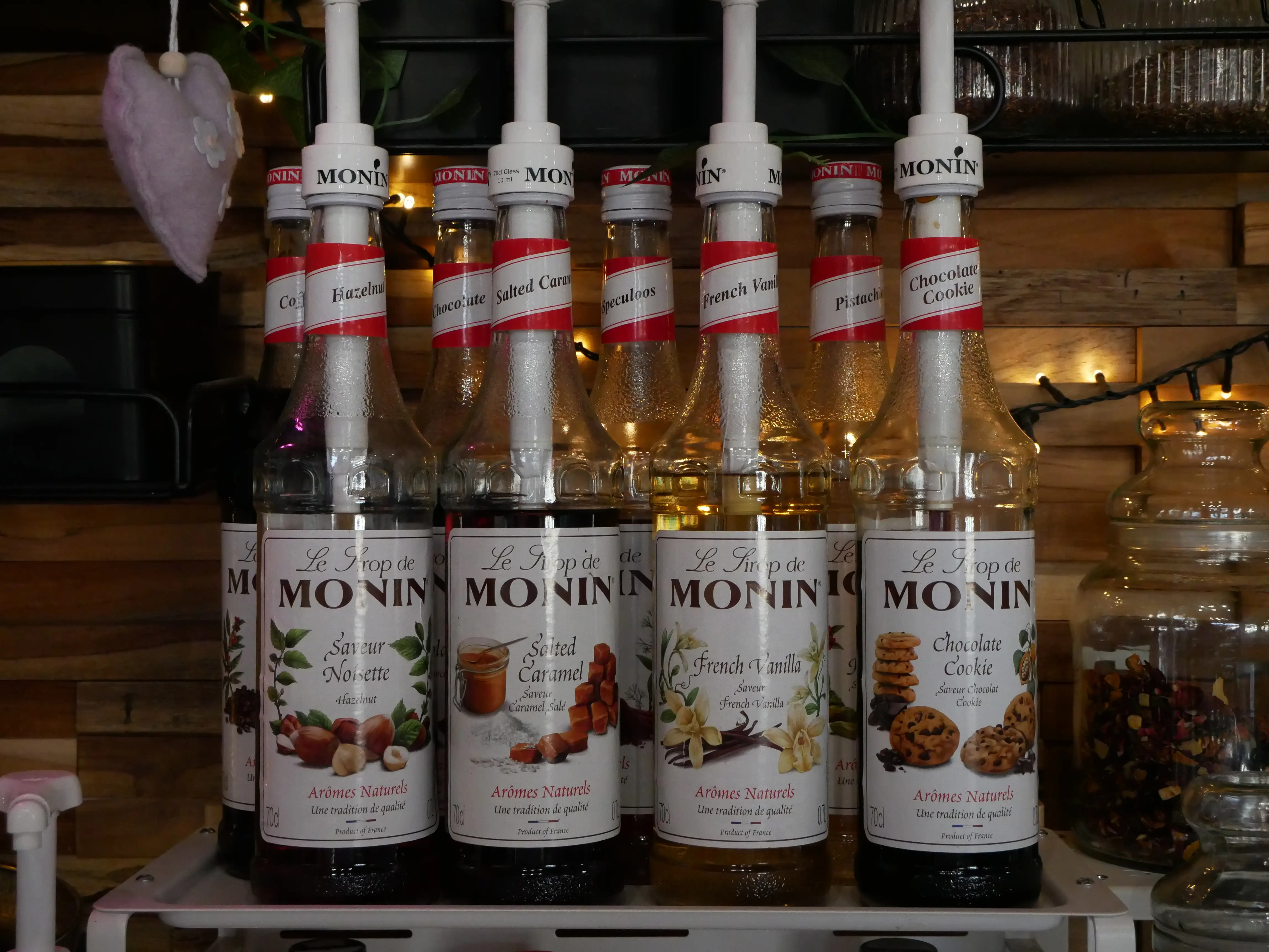 Bottles of Monin flavored syrup including Hazelnut, Salted Caramel, French Vanilla, and Chocolate Cookie.