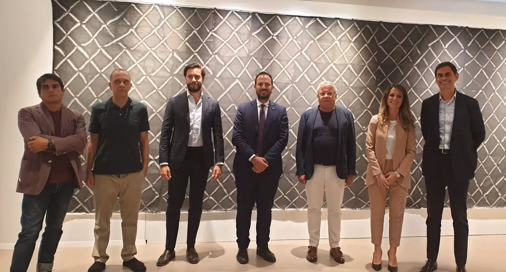 Sette persone in posa davanti a una parete decorata