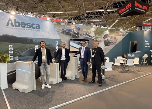 Stand Abesca in fiera, con quattro uomini accanto a barriere in calcestruzzo