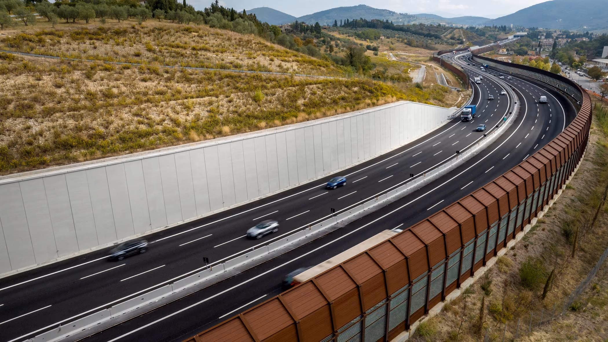 Tratto stradale con barriera antirumore in acciaio corten e muro in calcestruzzo