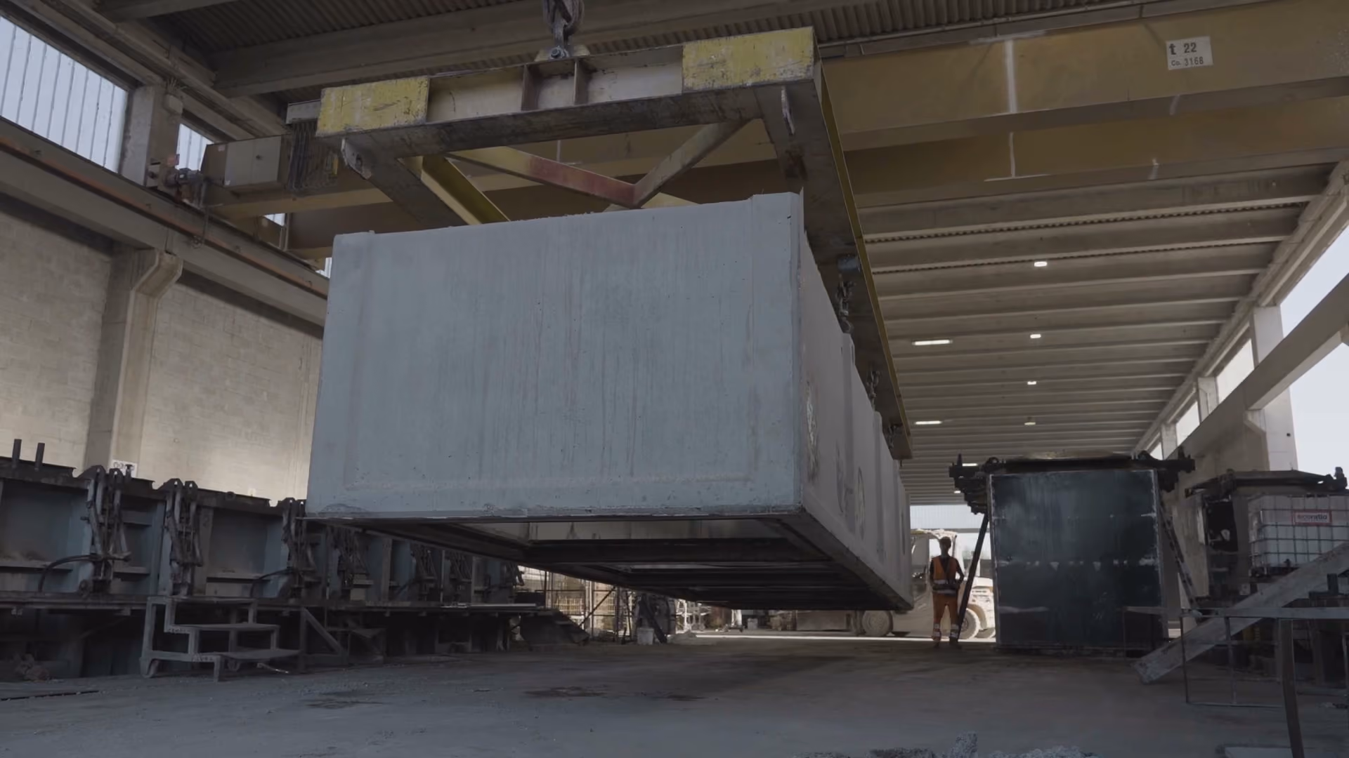 Vasca prefabbricata in calcestruzzo sospesa a un carroponte all'interno dello stabilimento