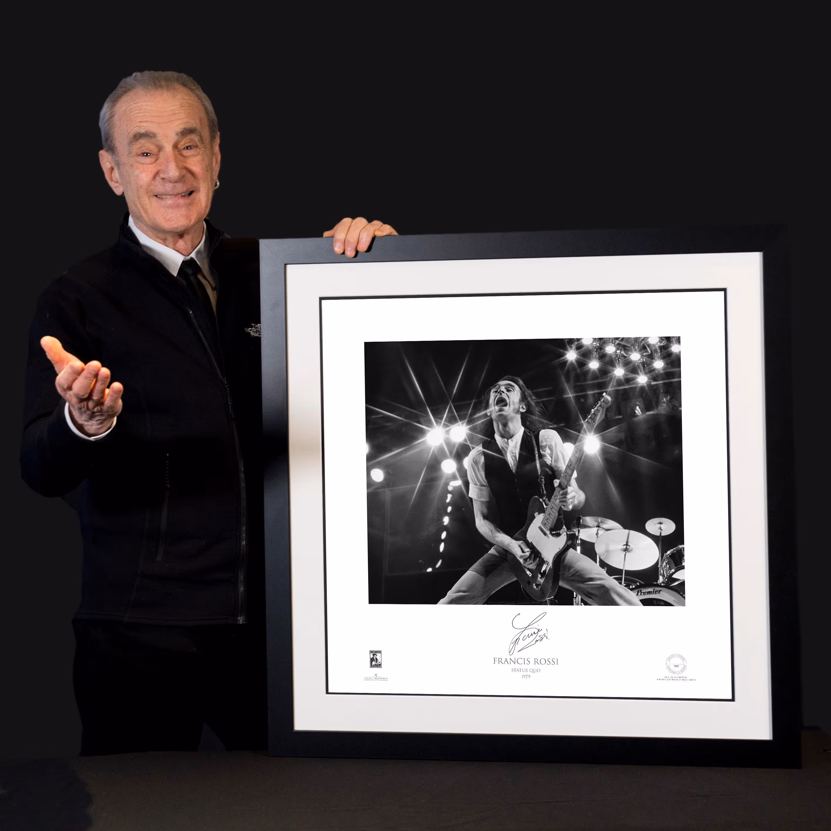 Man presenting framed signed music photograph