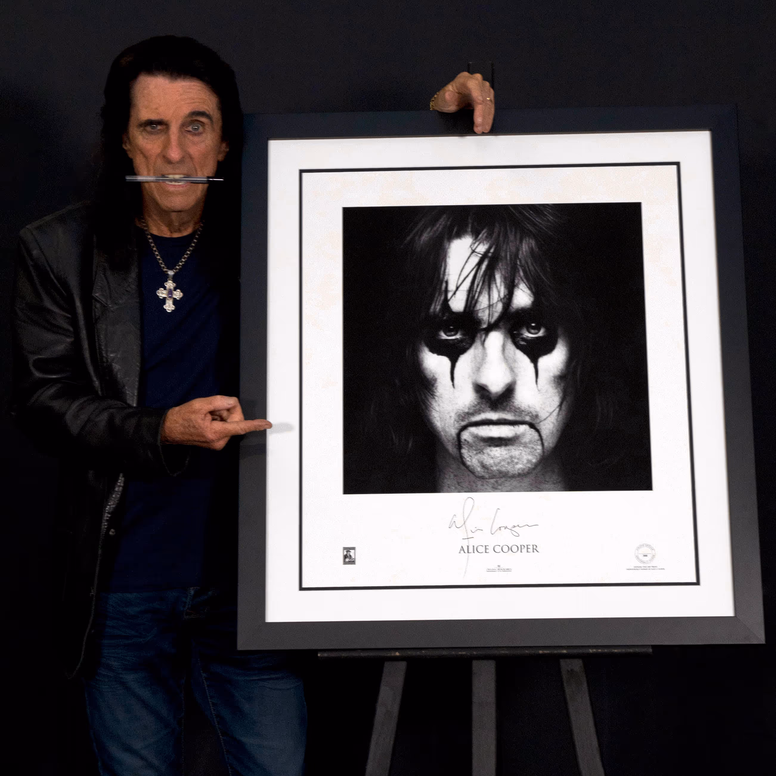 Man presenting framed John Lennon artwork