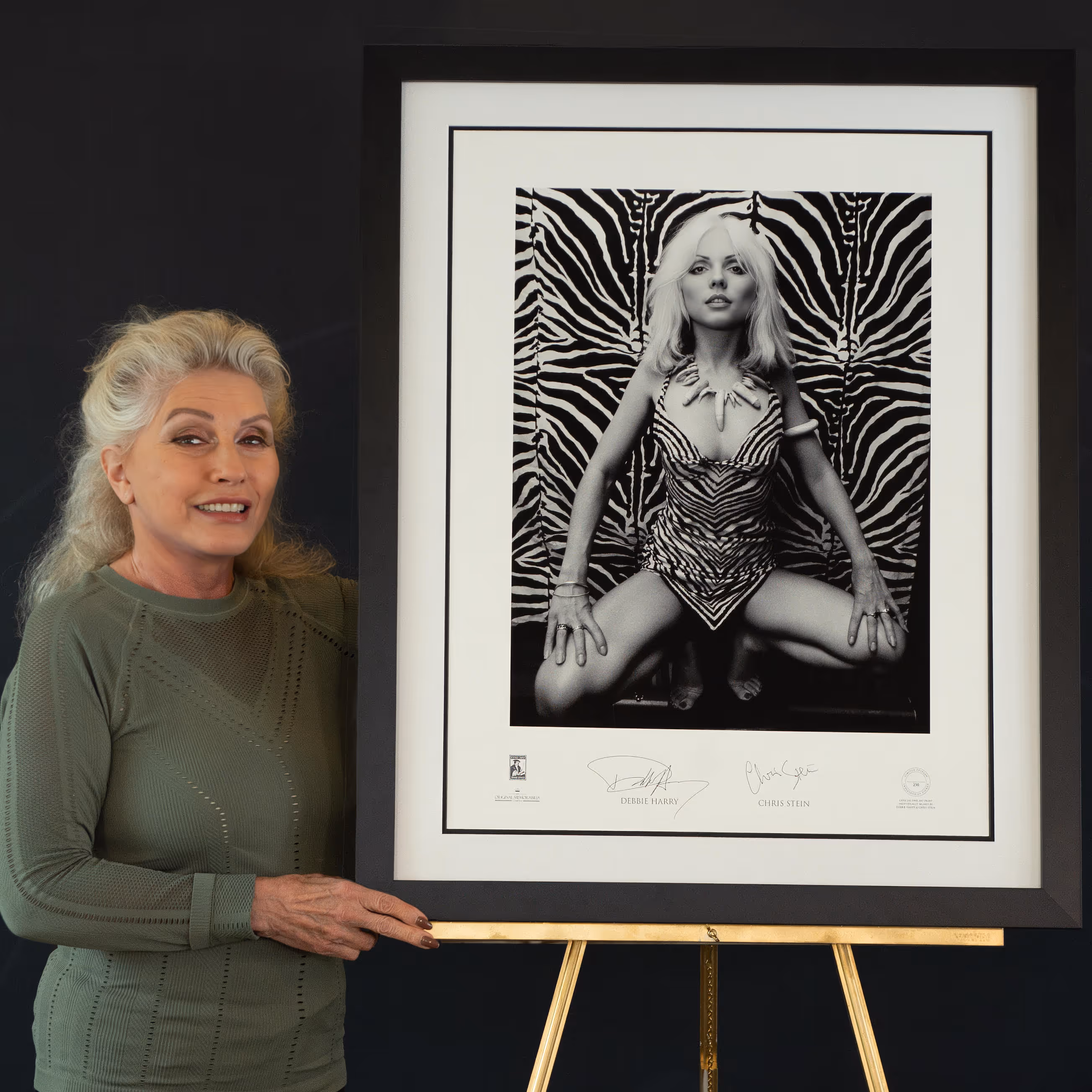 Woman presenting framed signed artwork
