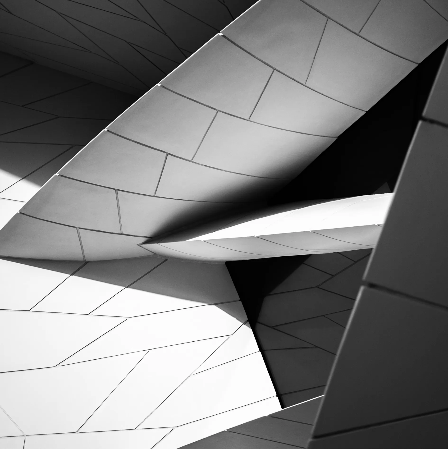 Abstract black and white geometric shapes overlapping with sharp angles and textured surfaces.