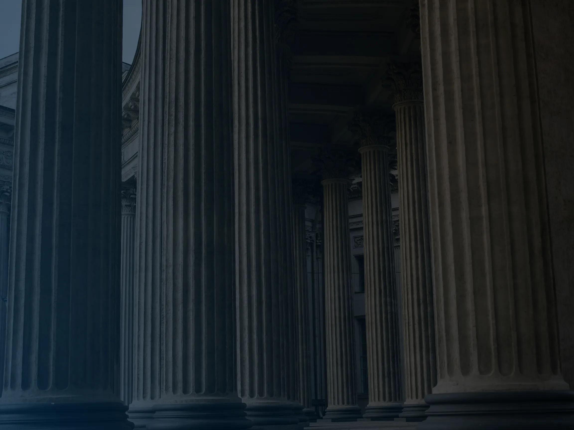 Row of large classical stone columns with fluted shafts and ornate capitals.