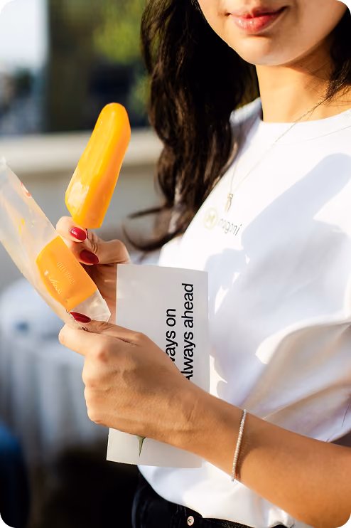 Nagomi team member holding a popsicle and a branded card