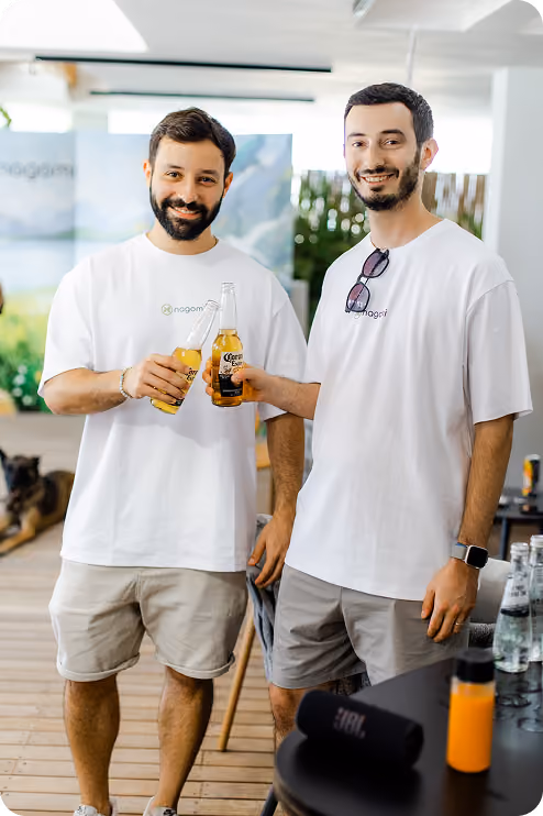 Two Nagomi team members toasting drinks together