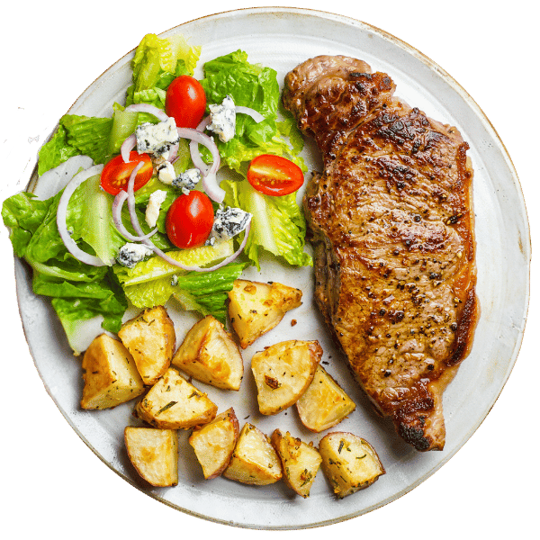Grillowany stek z pieczonymi ziemniakami i sałatką z sałaty, pomidorów koktajlowych, cebuli i sera.