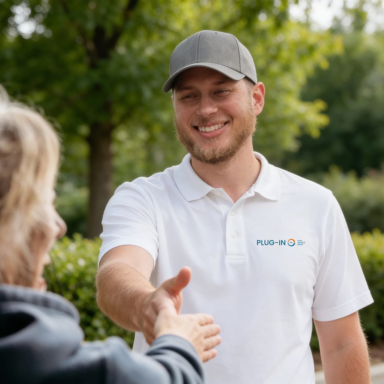 A Plug-In Services technician shaking hands with a satisfied customer