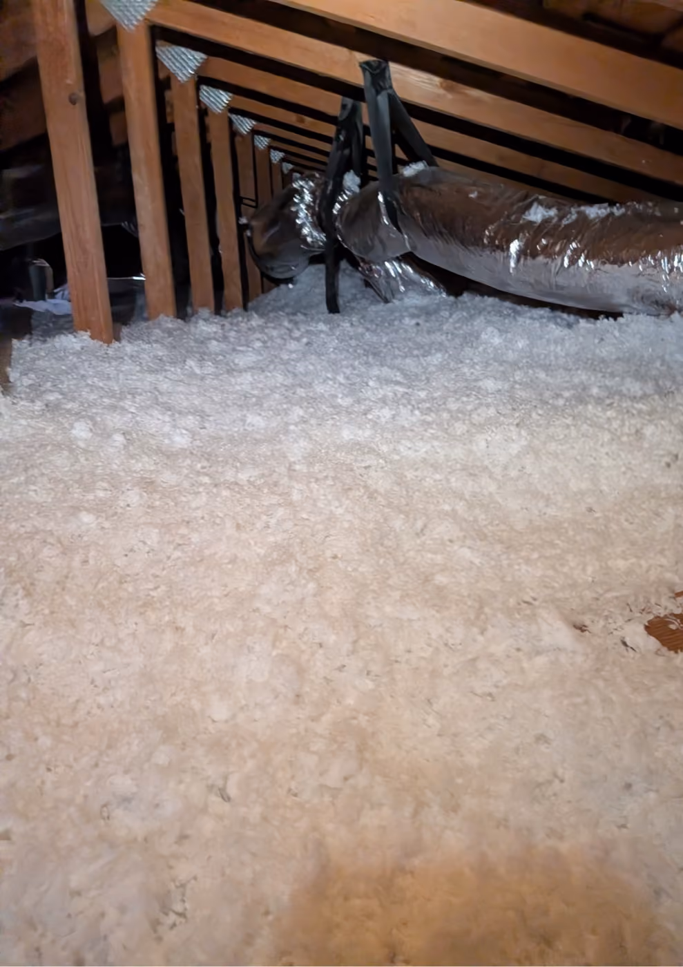 Finished blown-in attic insulation laid evenly between the joists.