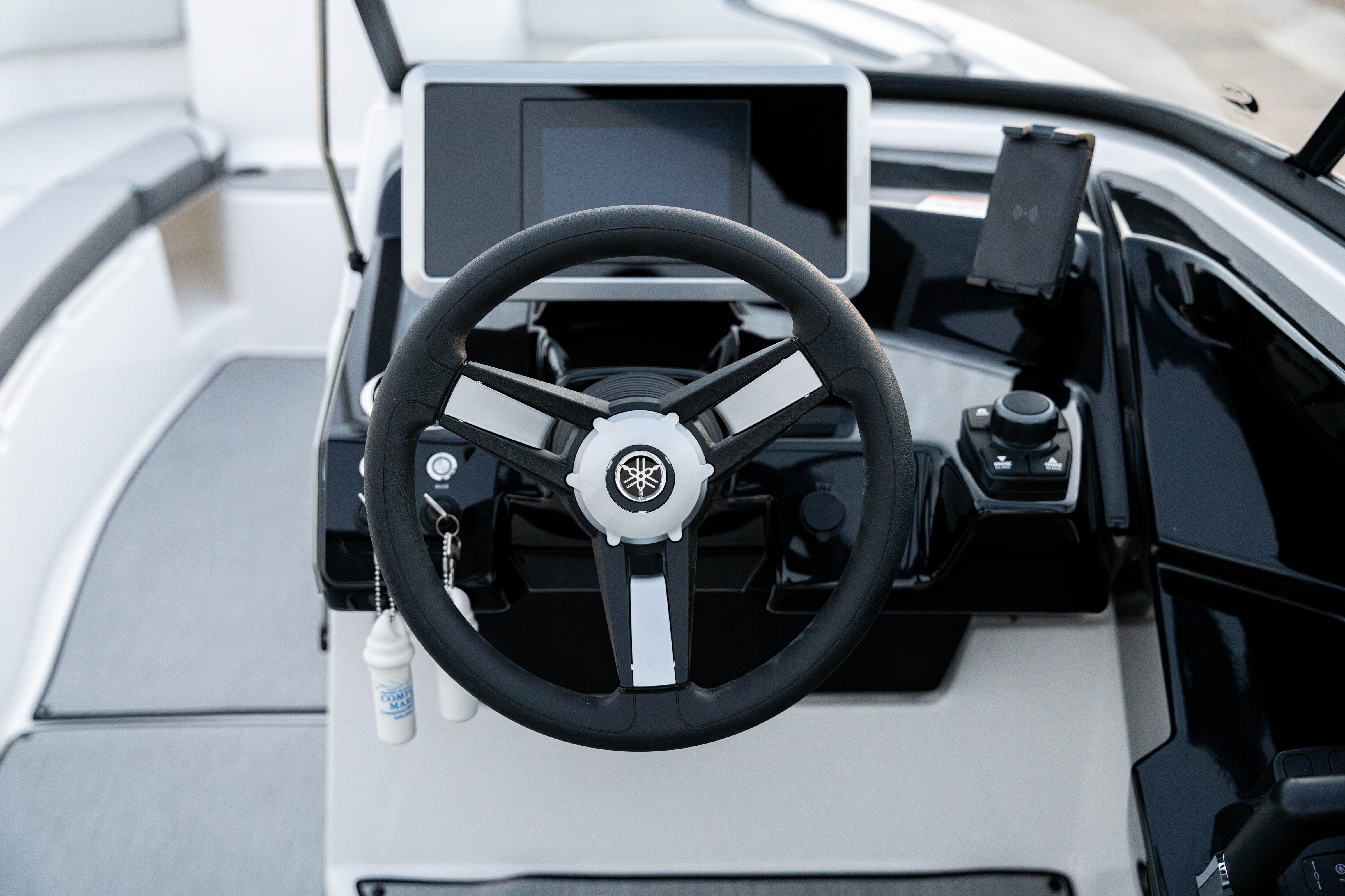 Boat steering wheel with Yamaha logo, control panel, and screen on the dashboard.