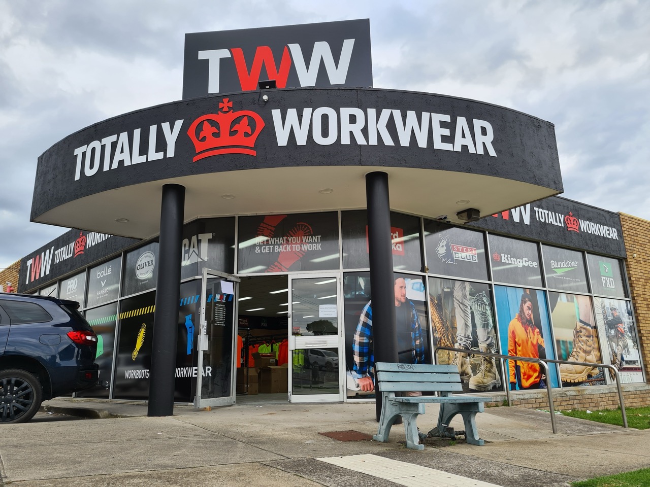 A photo of a shopfront for Totally Workwear that has large 3d signs on top