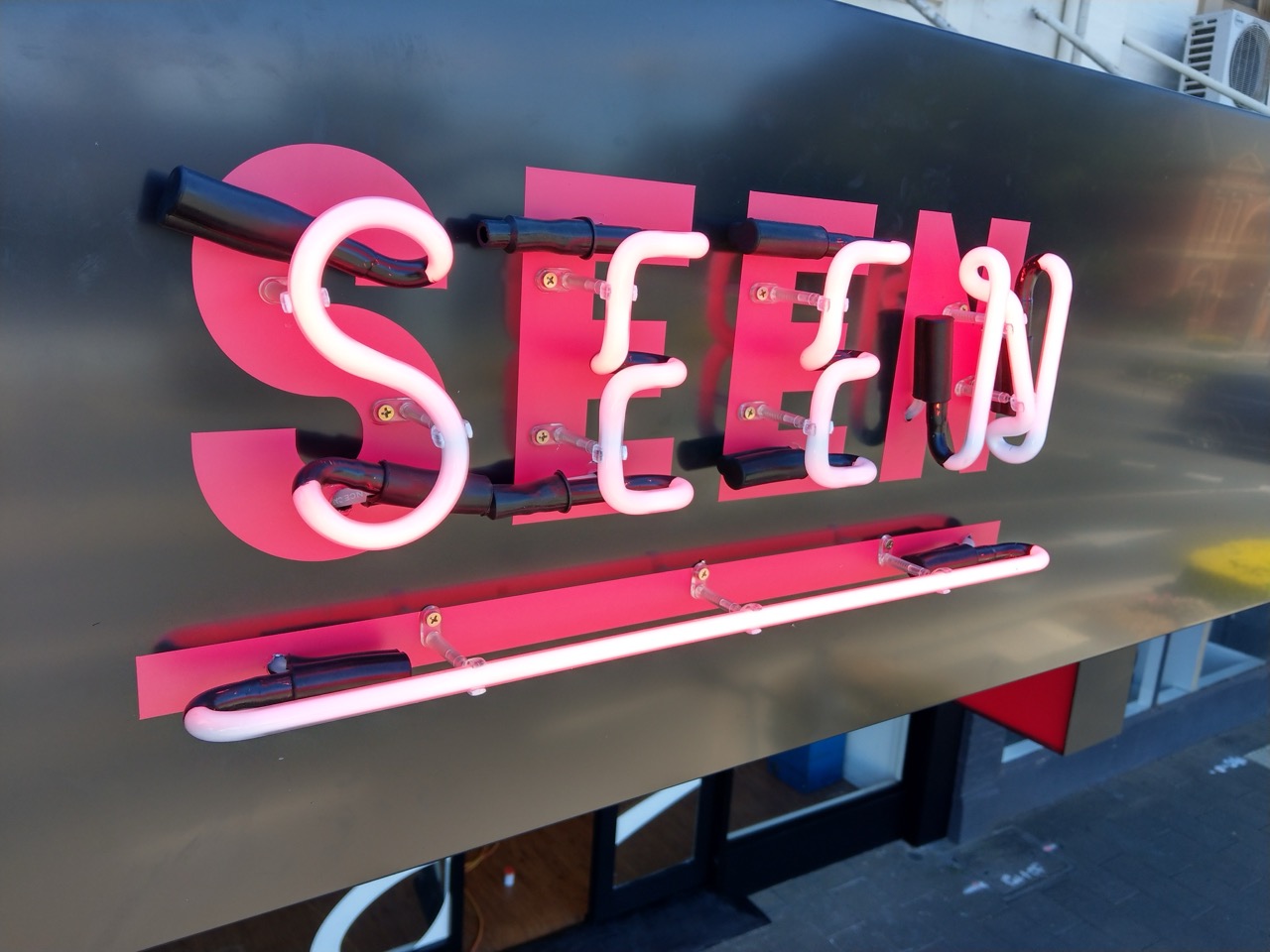 a red custom neon sign that says seen with a line underneath. Custom neon sign by MC Grafix and Signs Warragul