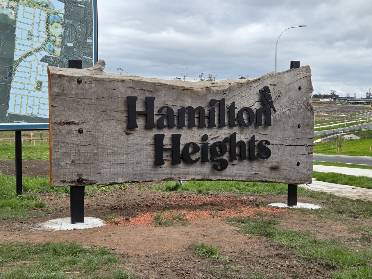 A rustic billboard sign made from old timber with 3d letters that say Hamilton Heights Drouin on it