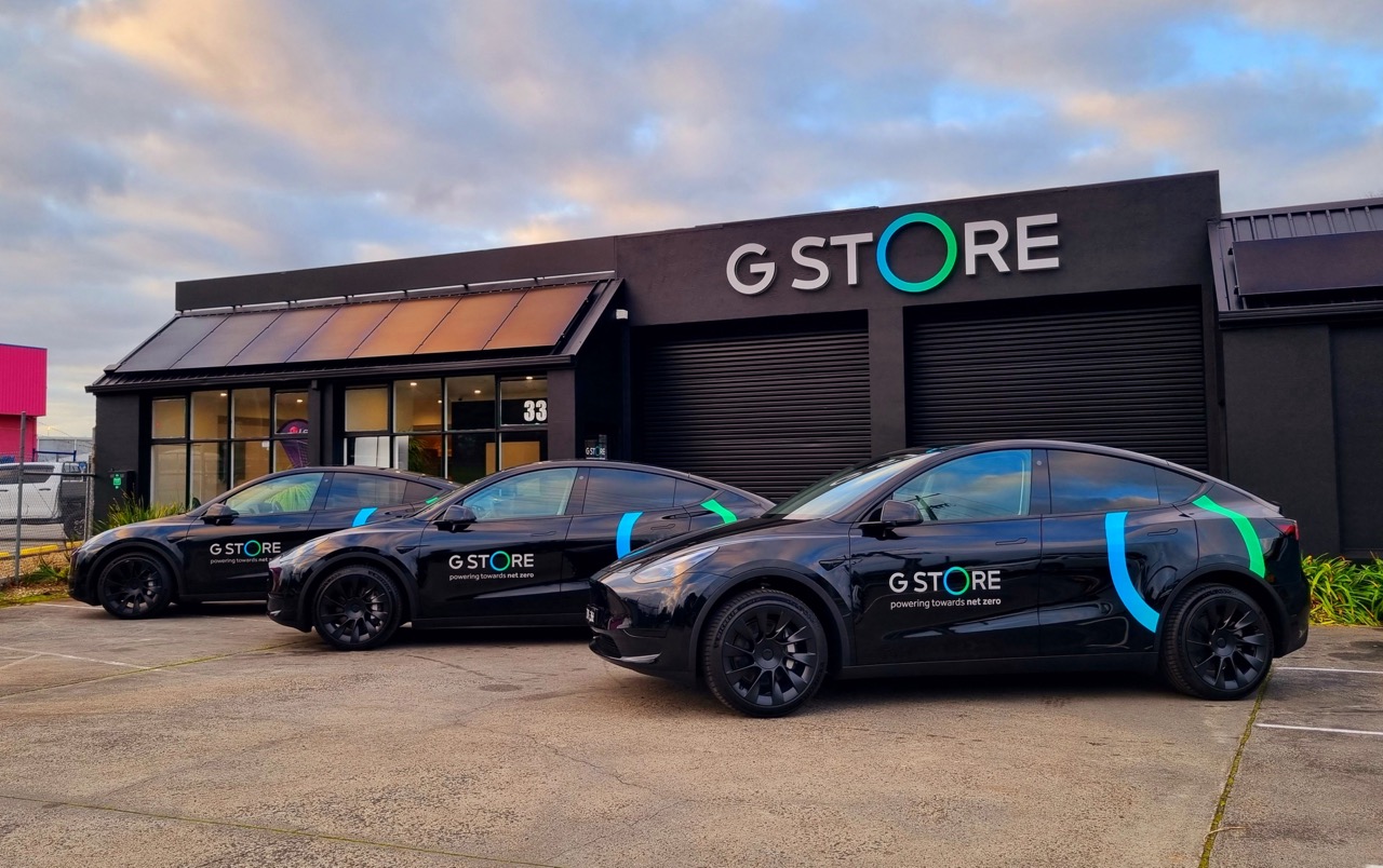 3 black teslas parked infront of a shop reading G Store with illuminated signage and car wraps in Melbourne