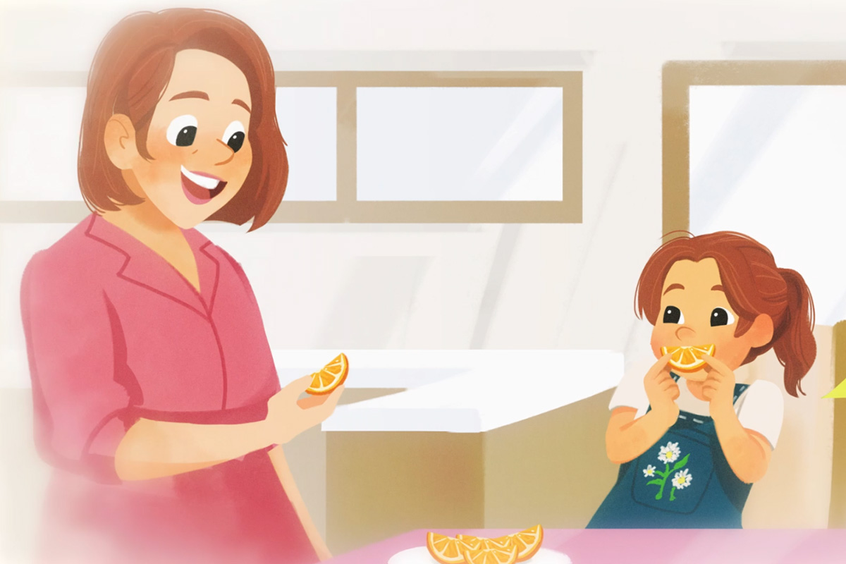 Woman and child smiling while holding orange slices in a bright kitchen.