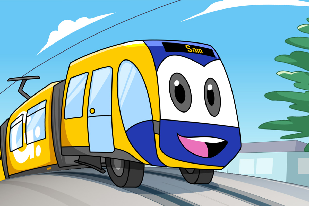 Cartoon yellow and blue tram named Sam with big eyes and a smiling mouth on a road.