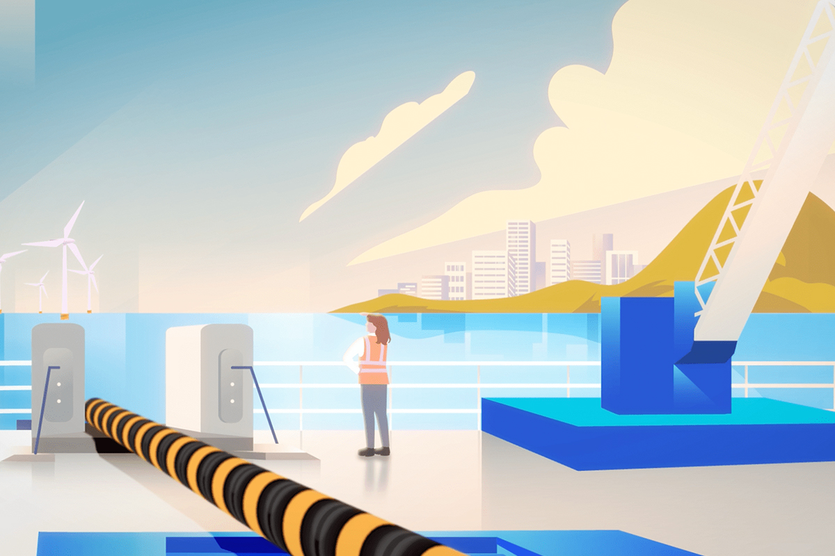 Worker in safety vest standing near large cable on dock with wind turbines and city in background.