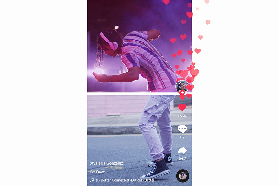 Video of young person dancing on street wearing striped top, headphones, and sneakers with heart reactions.
