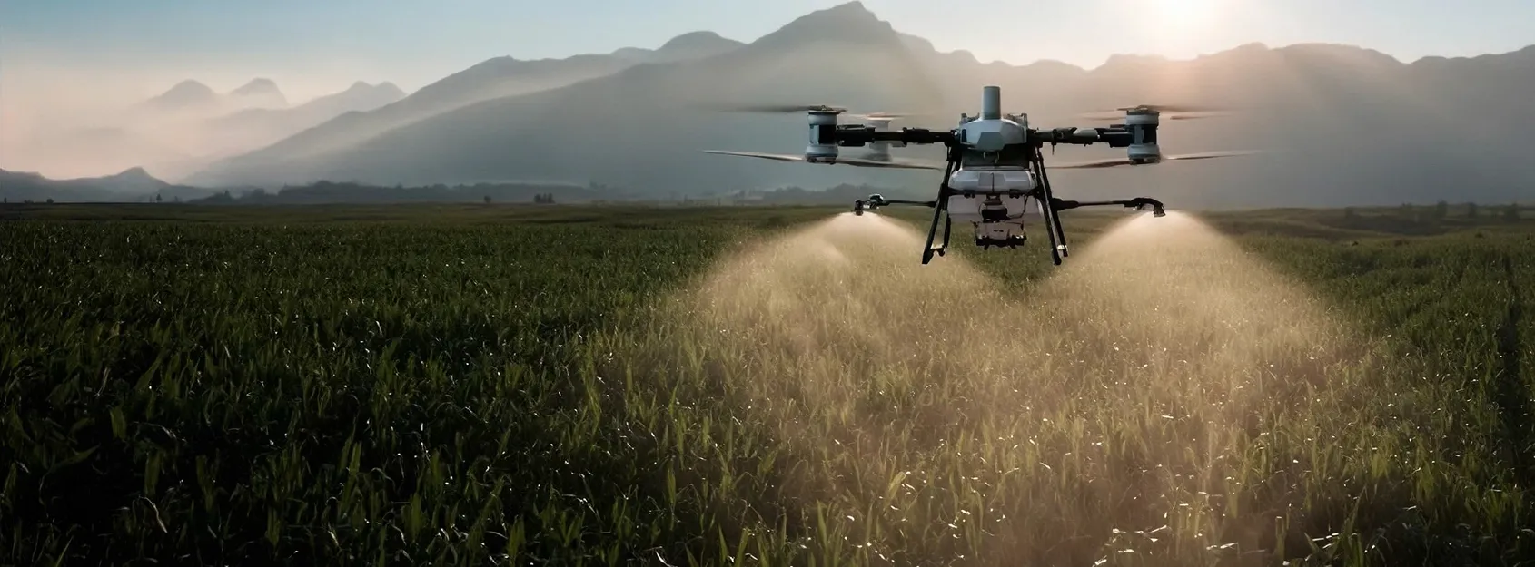 Dron agrícola fumigando un campo con montañas al fondo al atardecer.
