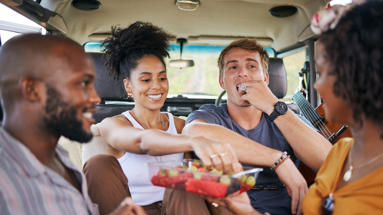 A group of friends on a road trip sharing gluten free food they packed