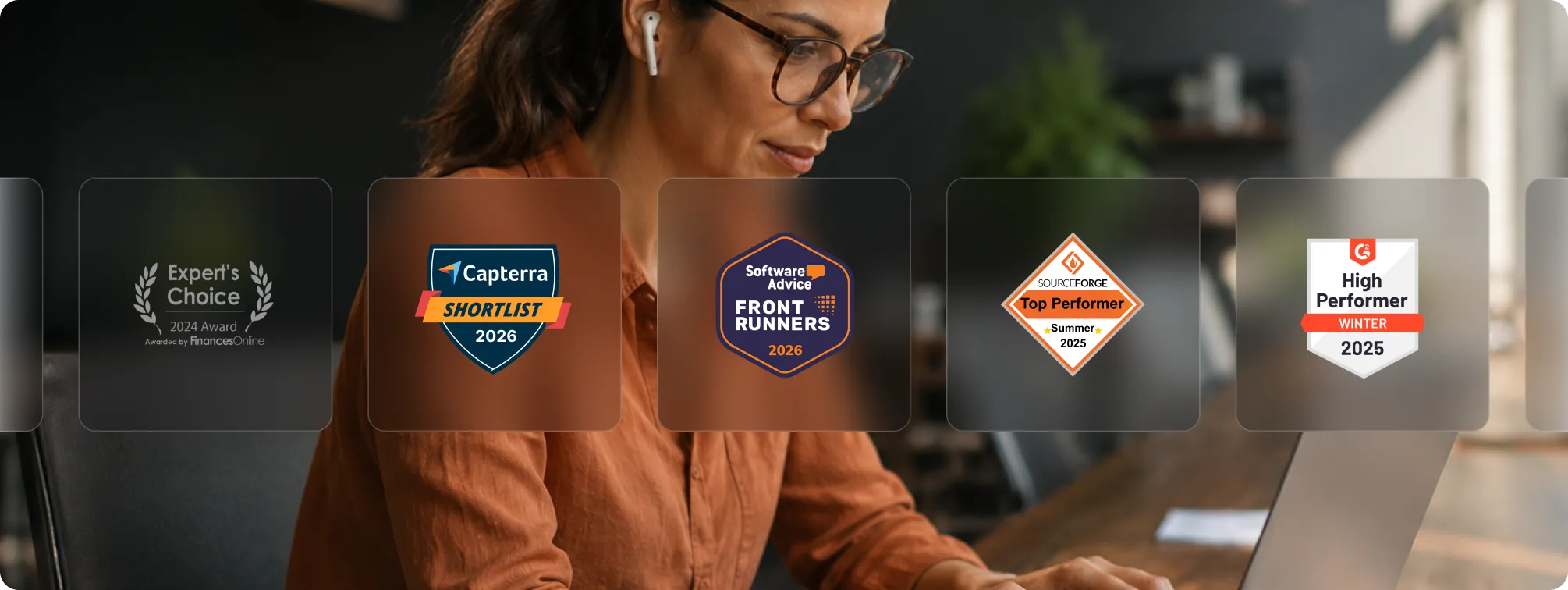 Tradogram industry award badges displayed alongside a professional working at a laptop.