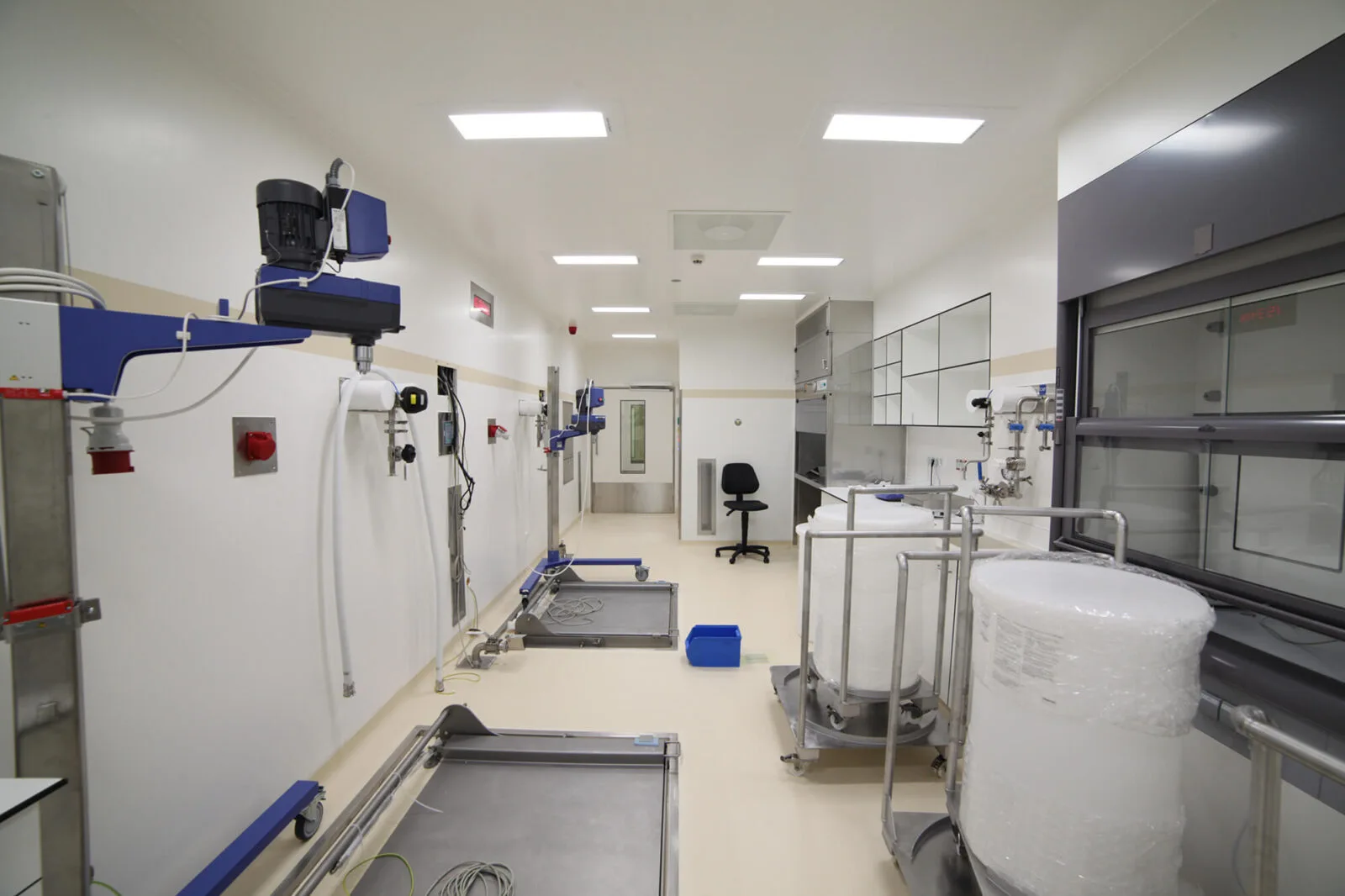 Laboratórium folyosója fehér tartályokkal és csővezetékekkel
