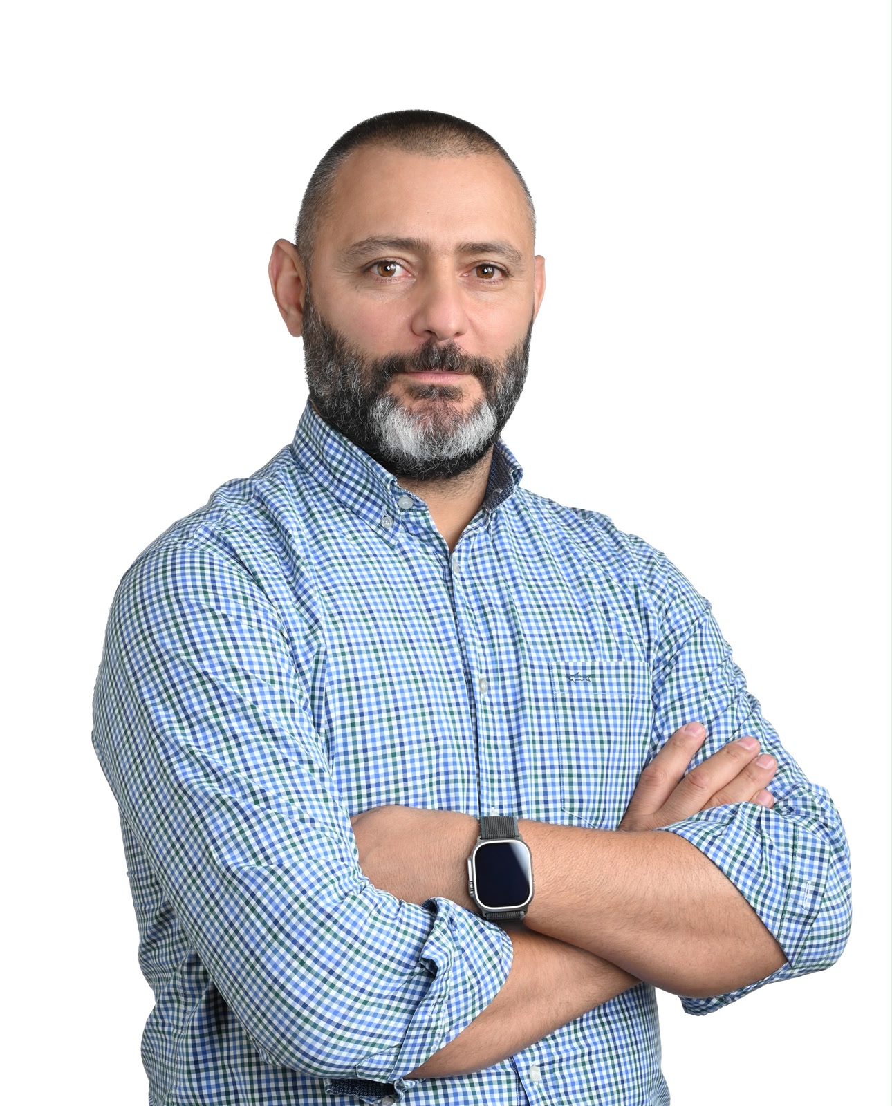 Confident man with short hair and beard wearing black vest, gray shirt, and blue neck scarf.